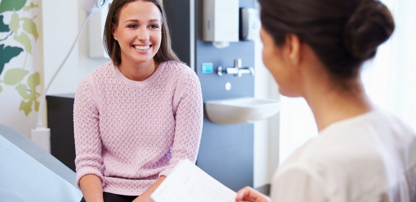Female Patient And Doctor Have Consultation In Hospital Room