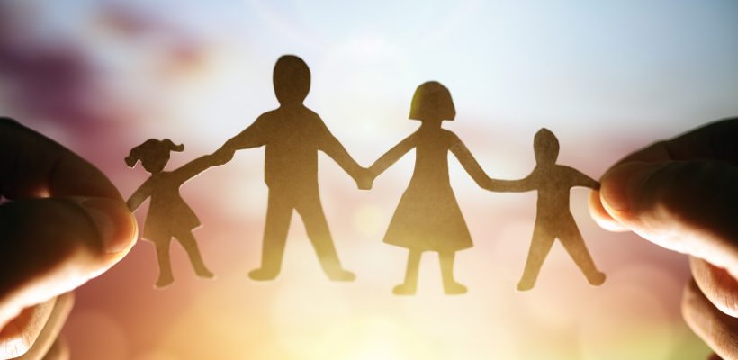Paper chain family held up to sunset