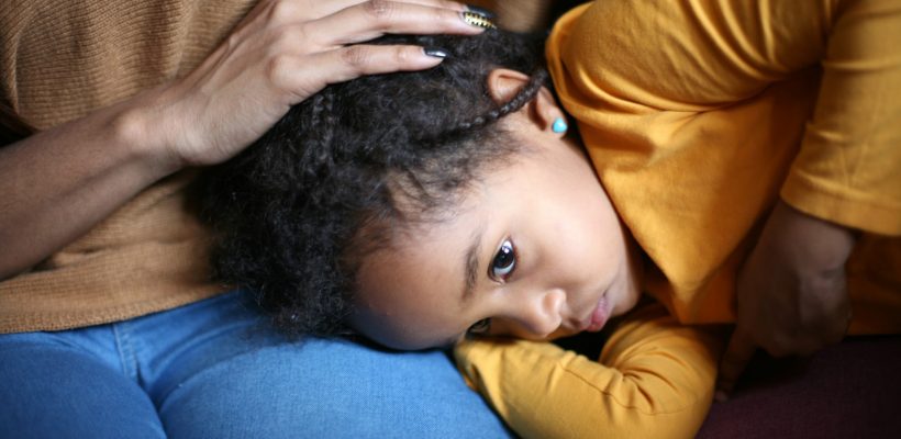 Sad girl being consoled by mother